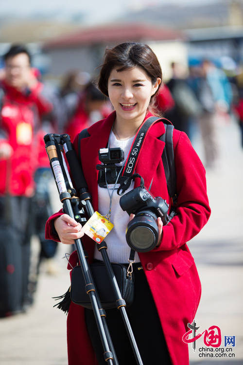 2016年兩會，人民大會大堂前，一位笑容燦爛的紅衣女記者正步入大會堂。中國網(wǎng) 鄭亮 攝