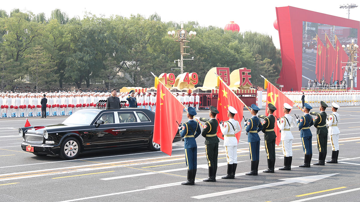 習近平驅(qū)車行進至黨旗、國旗、軍旗前，向旗幟行注目禮