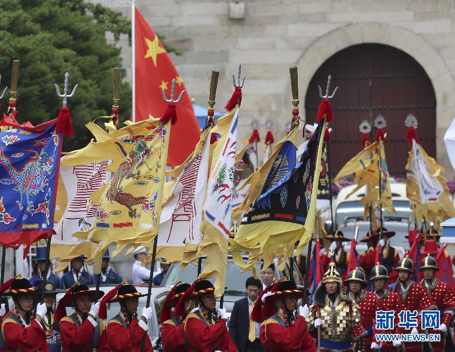 7月3日，韓國總統(tǒng)樸槿惠在青瓦臺總統(tǒng)府舉行隆重儀式，歡迎中國國家主席習(xí)近平對韓國進行國事訪問。這是習(xí)近平的車隊在身著民族服裝的韓國禮儀隊伍引導(dǎo)下駛?cè)肭嗤吲_。新華社記者丁林?jǐn)z  